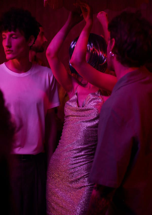 Adultos conversando y bailando en un evento nocturno